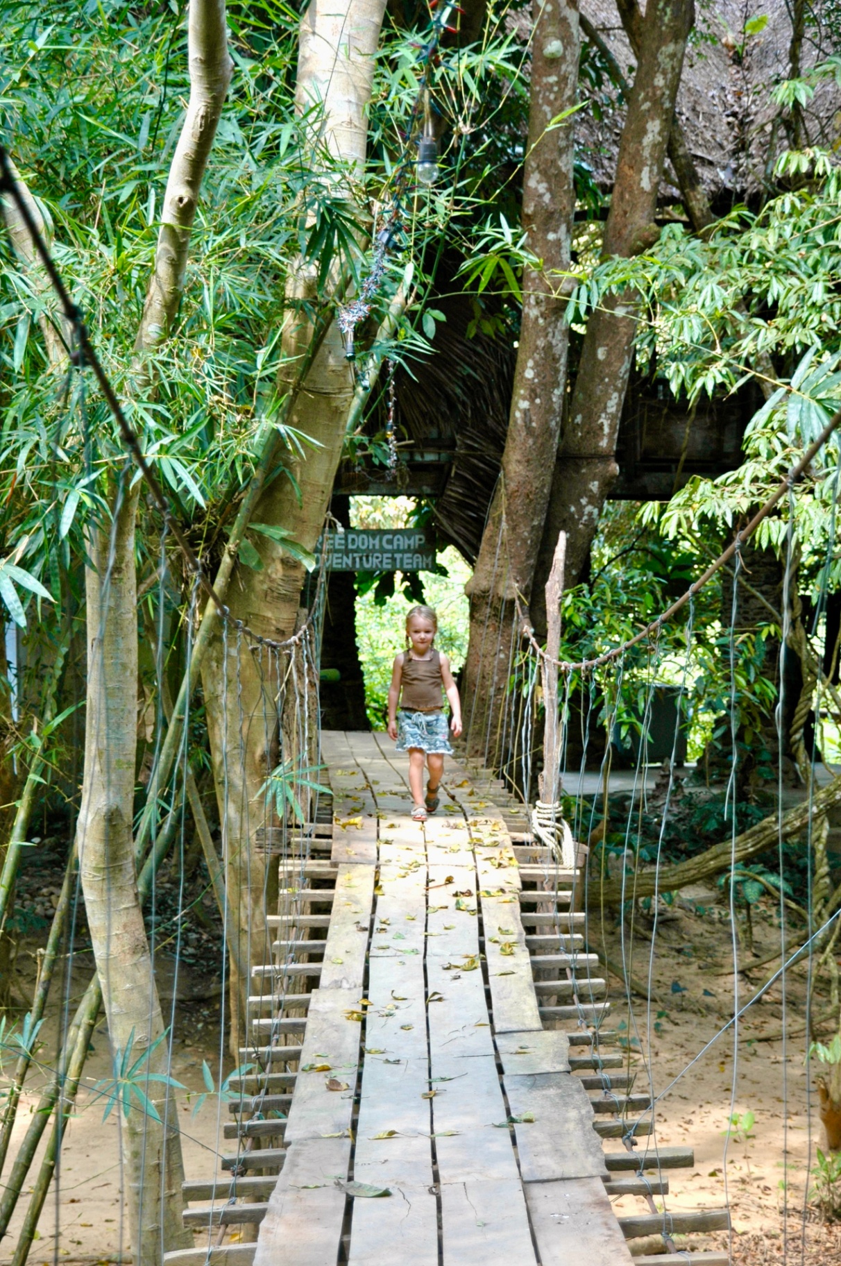 Kind op hangbrug in jungle